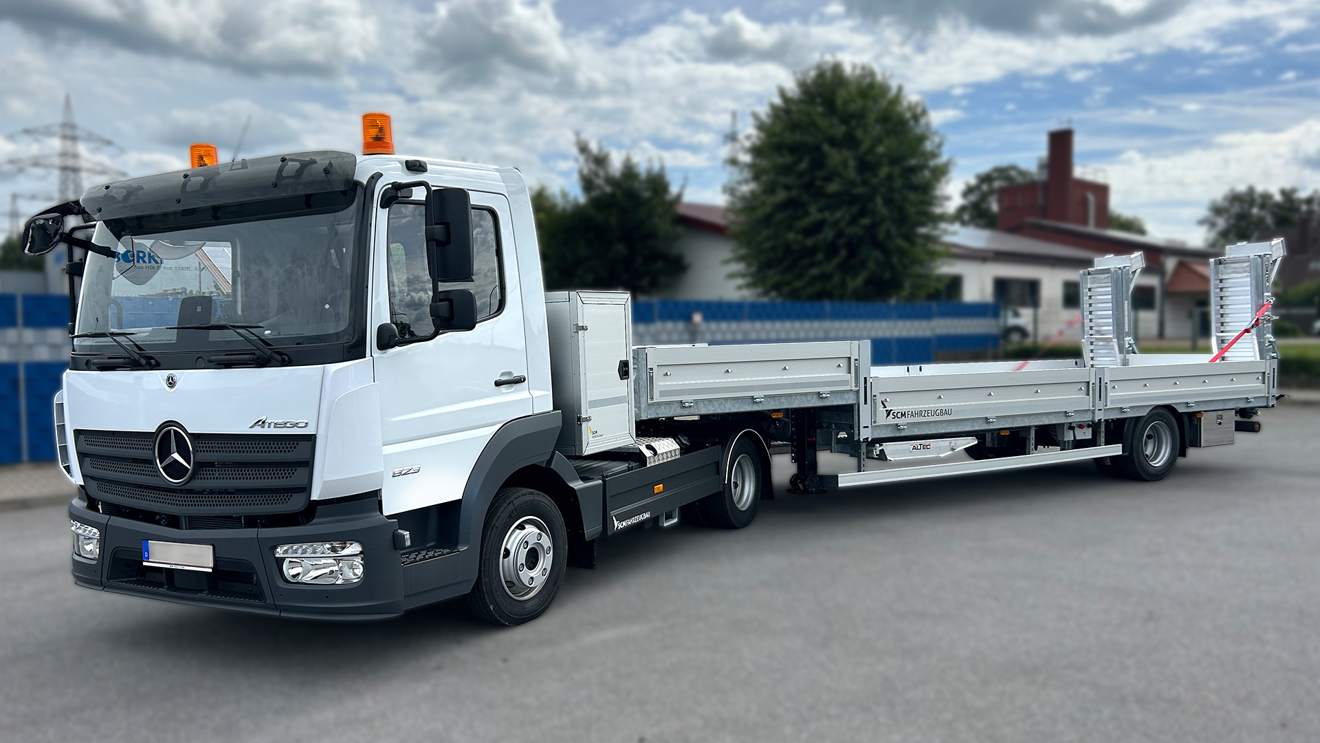 Truck with custom-built center axle trailer in the yard of a company premises