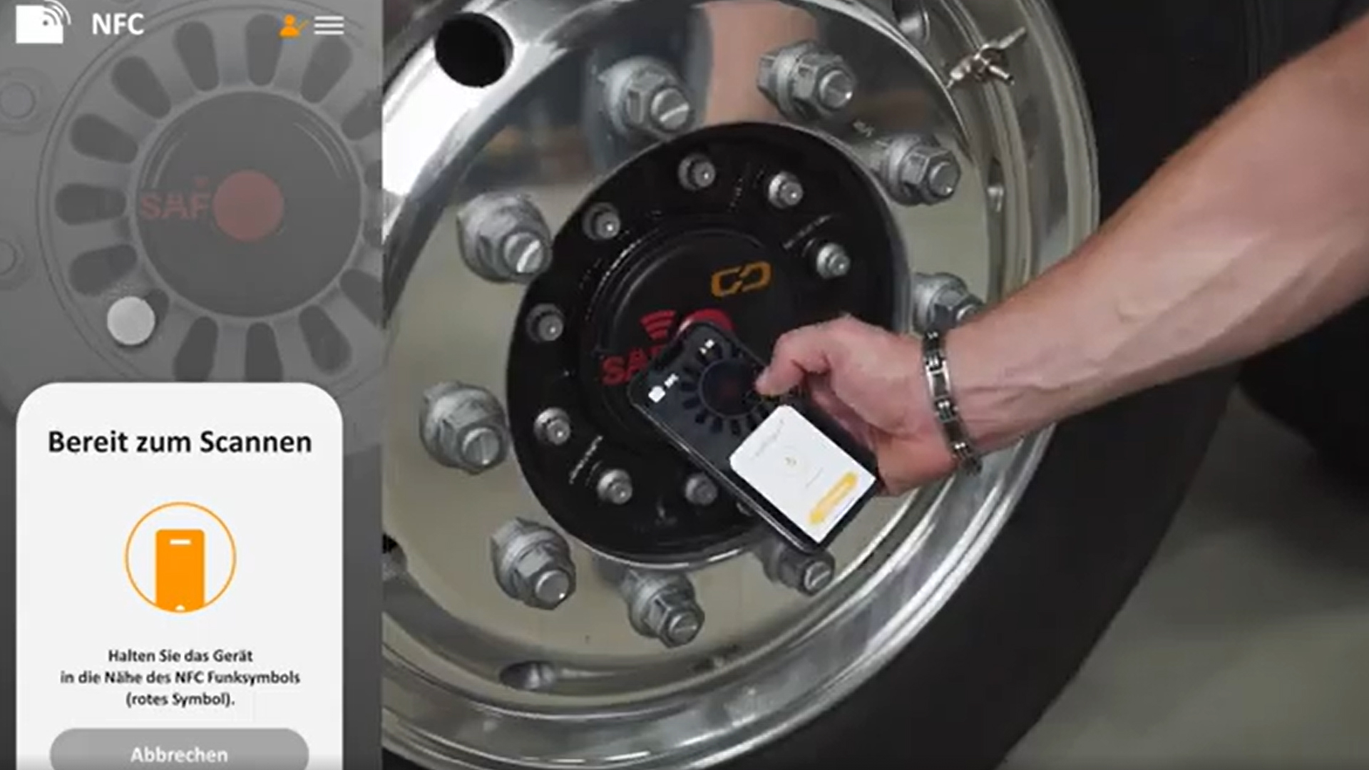 Person uses a smartphone to scan an NFC-enabled truck wheel hub.