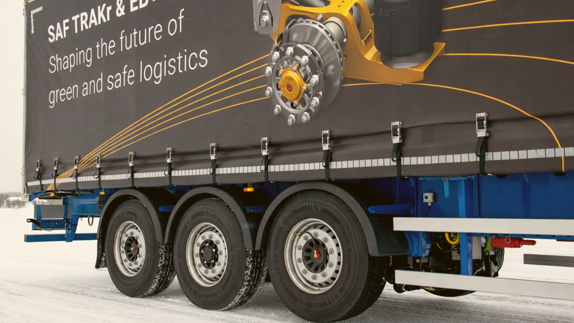 Trailer with SAF-HOLLAND branding on snowy road, promoting green and safe logistics.