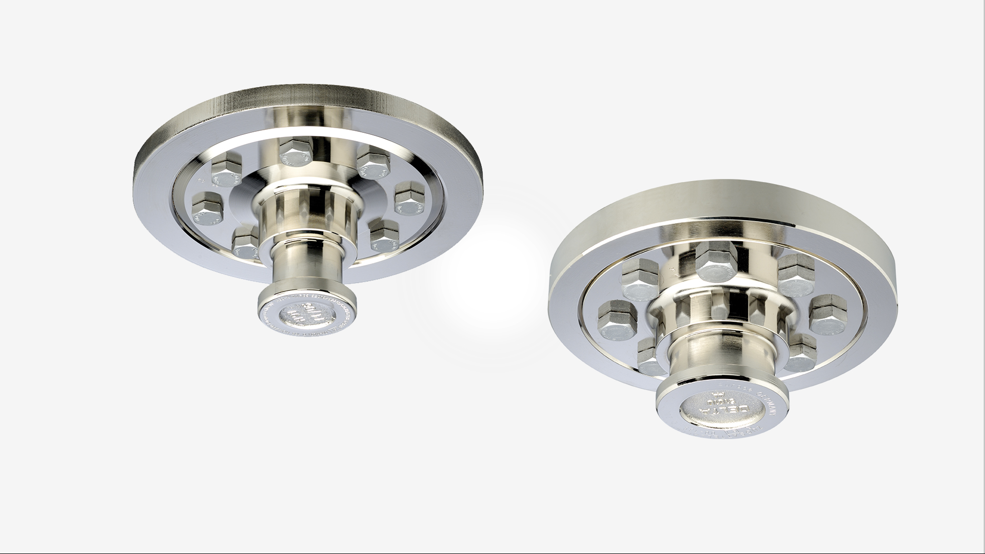 Two SAF metal kingpins for truck trailers, by SAF-HOLLAND, viewed from below.